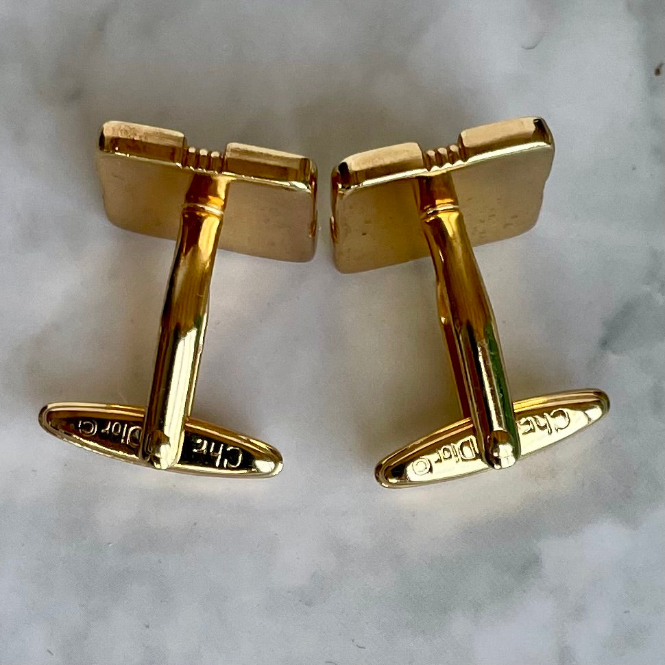 reverse of vintage Christian Dior two-tone cufflinks. Timeless geometric square design with a light grey/white inlay and gold-plated ribbed edges. Signed Chr. Dior © showing toggle fittings