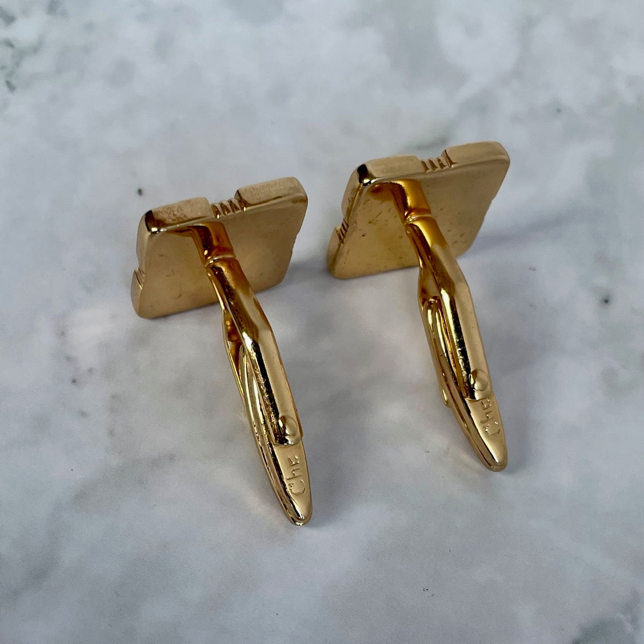 reverse of vintage Christian Dior two-tone cufflinks. Timeless geometric square design with a light grey/white inlay and gold-plated ribbed edges. Signed Chr. Dior © showing toggle fittings