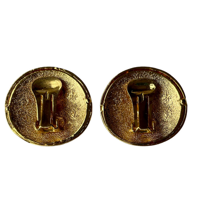 reverse side side of a pair of vintage 1980s Helena Rubinstein Paris domed clip-on earrings. Each button-style earring features a smooth, cream-colored faux pearl base overlaid with intricate gold-tone fluting and two interlocking circular motifs encrusted with small, glittering clear rhinestones, showing the clips