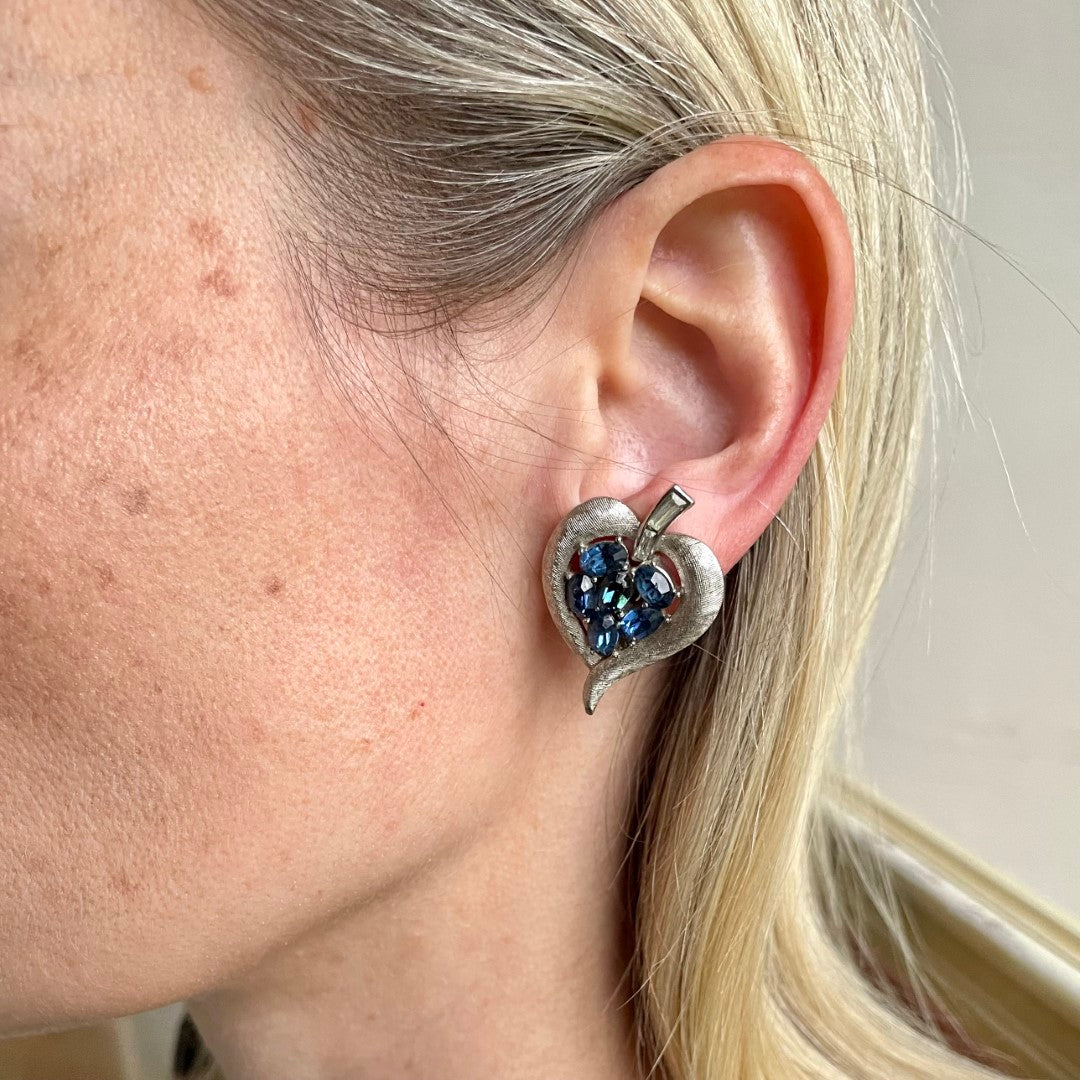 Vintage Crown Trifari cornflower blue oval crystal clip earrings in brushed silver Trifanium, signed, with clear baguette stones. Alfred Philippe era, 1960s. shown on model