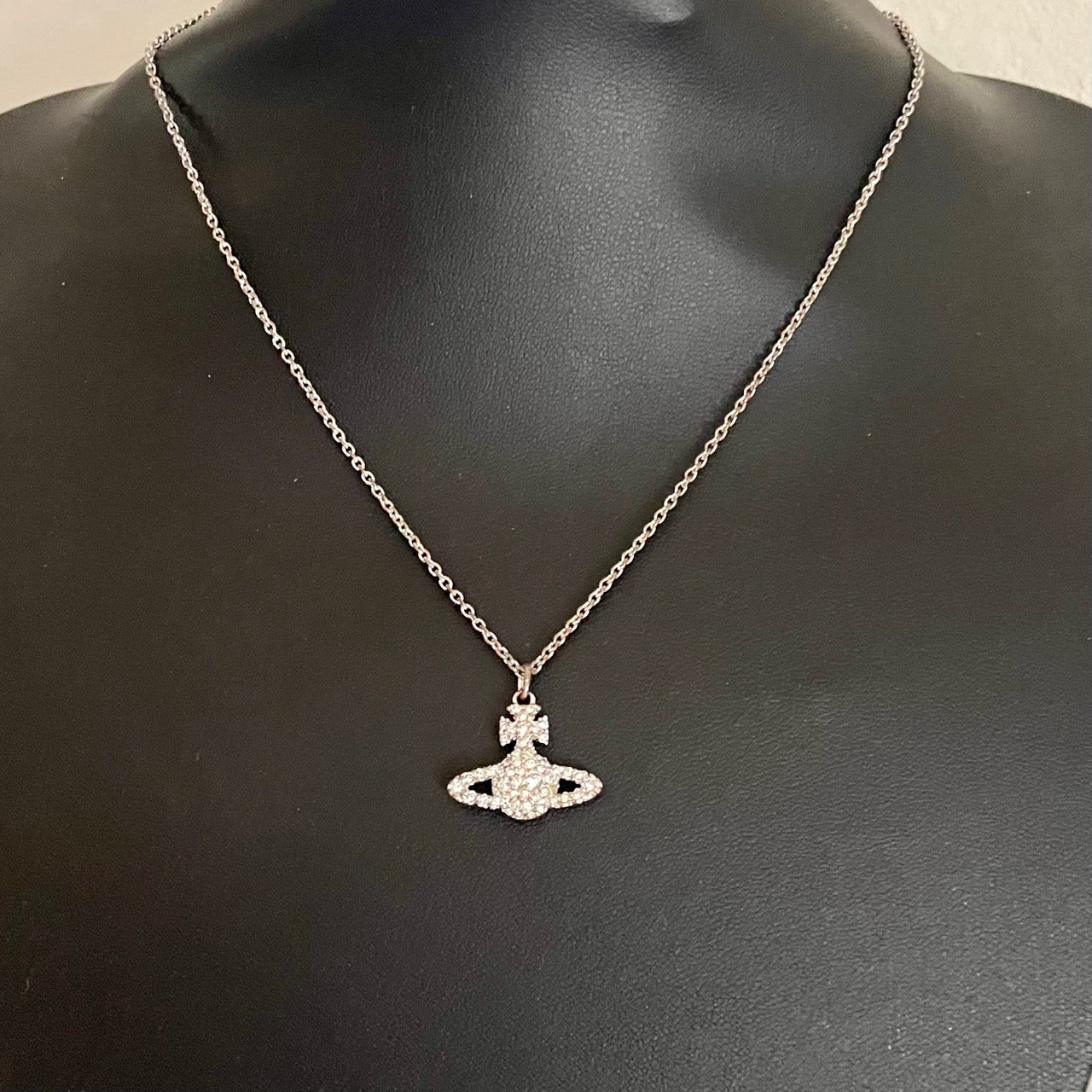 A silver-tone Vivienne Westwood crystal-encrusted mini orb pendant necklace displayed on a black background.