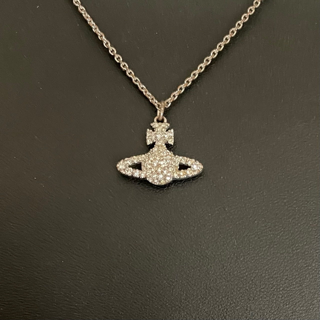 A silver-tone Vivienne Westwood crystal-encrusted mini orb pendant necklace displayed on a black background.