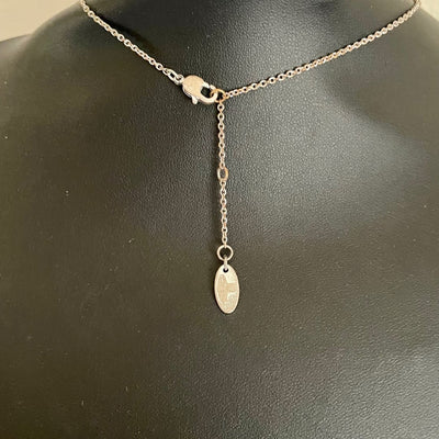 the lobster clasp and extender chain of  silver-tone Vivienne Westwood crystal-encrusted mini orb pendant necklace displayed on a black background.
