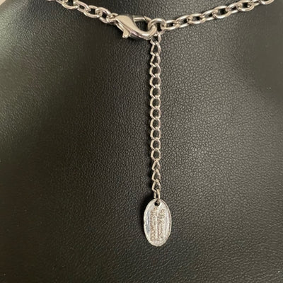 reverse of  Vivienne Westwood vintage necklace showing silver chain and tag on a white background
