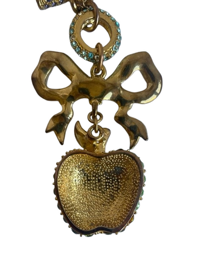 reverse of gold tone Vivienne Westwood vintage necklace with a colorful bow and green apple pendant on a white background