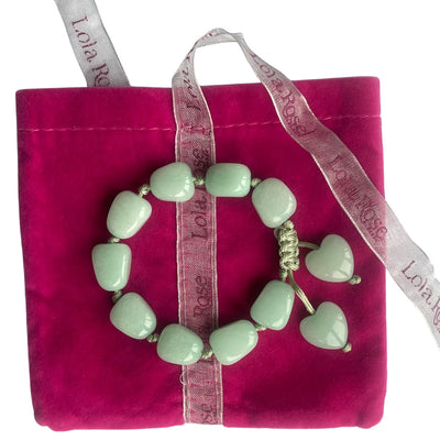 Lola Rose aqua jade green quartzite gemstone adjustable bracelet with dangling heart charms on a hot pink velvet gift pouch with branded ribbon.