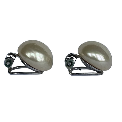 side view of Pair of vintage Christian Dior button pearl earrings on a white background