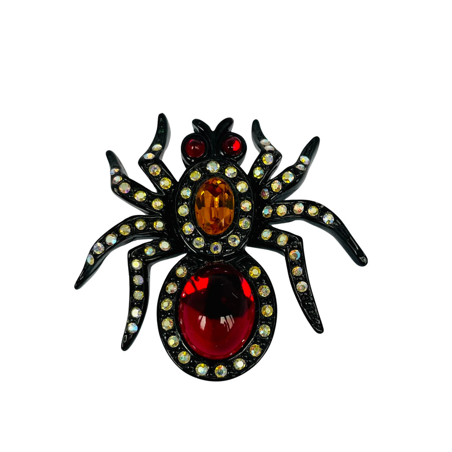 Early vintage Butler & Wilson black-coated metal mini spider pin with ruby red cabochon body, amber thorax crystal, and shimmering AB crystal legs.