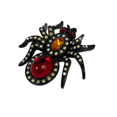 Early vintage Butler & Wilson black-coated metal mini spider pin with ruby red cabochon body, amber thorax crystal, and shimmering AB crystal legs.