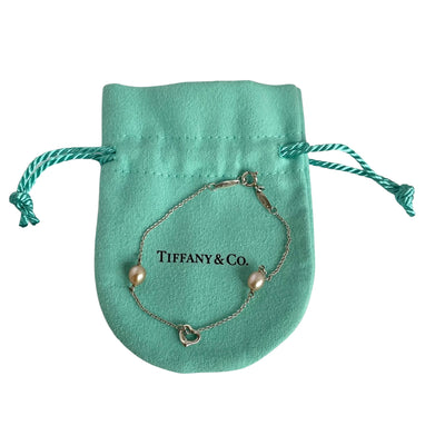 Tiffany & Co. Elsa Peretti Silver bracelet with pink pearls on a white background shown on original Tiffany pouch