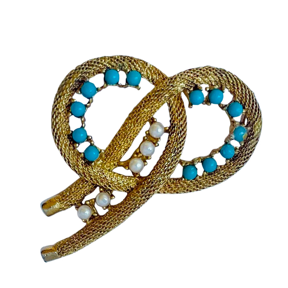 Vintage signed Dorene brooch showing a textured gold mesh knot design with turquoise beads and faux pearls on a white background