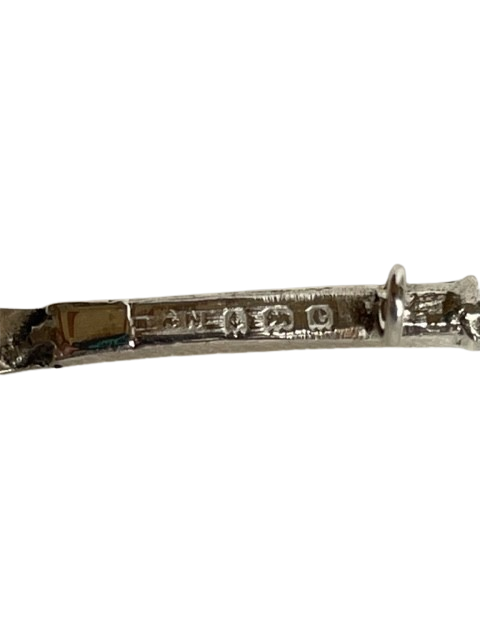 Antique sterling silver tennis racquet brooch showing hallmarks on a white background