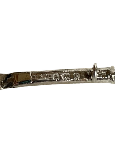 Antique sterling silver tennis racquet brooch showing hallmarks on a white background