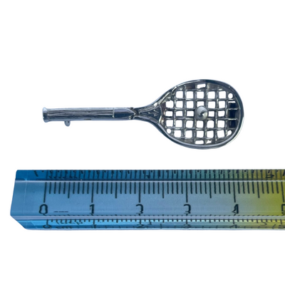 Antique sterling silver tennis racquet brooch next to ruler showing size