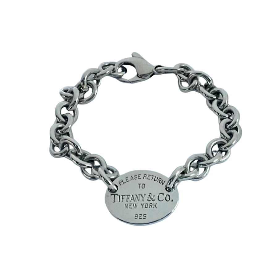A silver chain bracelet with a round oval tag engraved with 'PLEASE RETURN TO TIFFANY & CO. NEW YORK 925'.