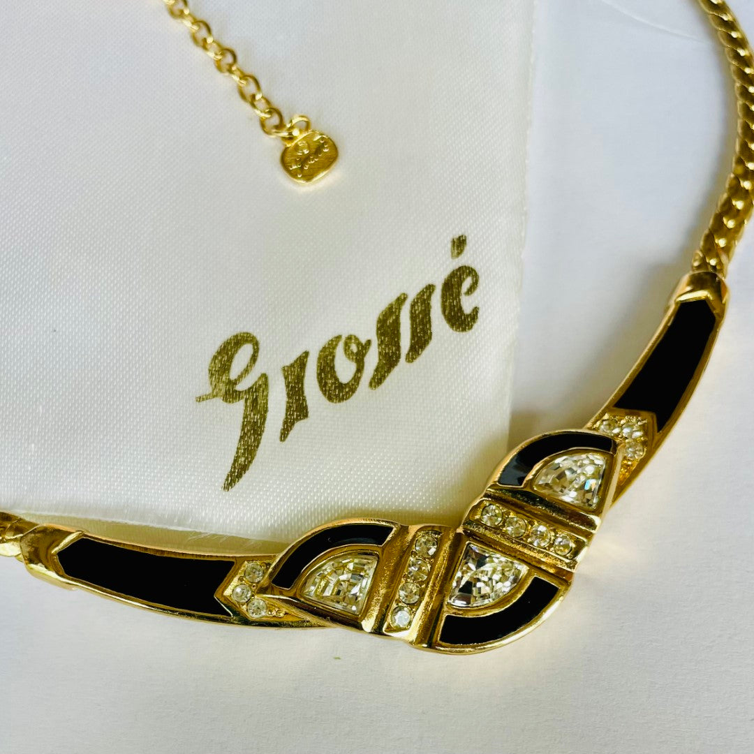 Gold necklace with black accents and gemstones on a white background with 'Grossé' branding.