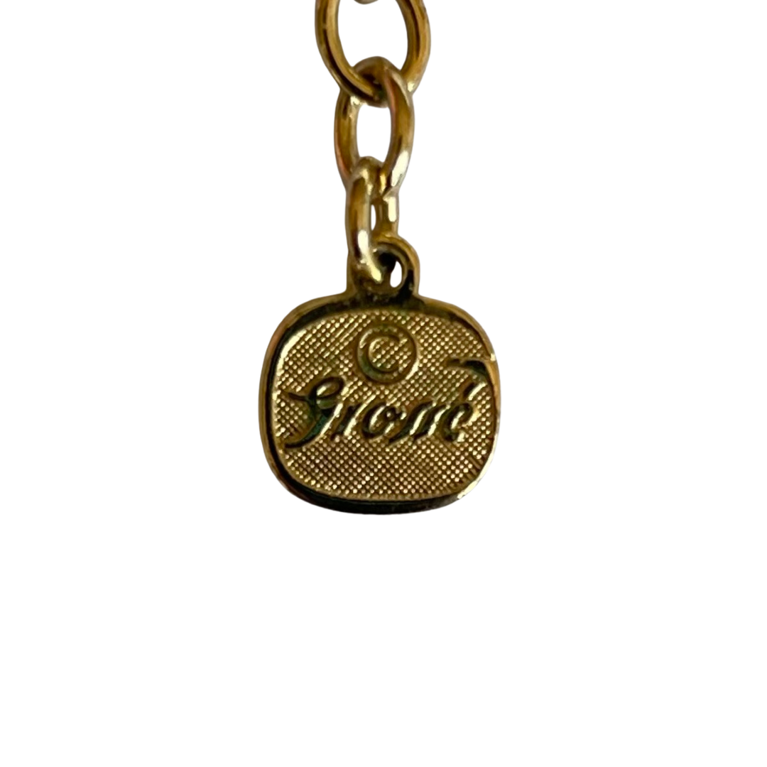 Gold necklace with black accents and gemstones on a white background showing  'Grossé' hallmark