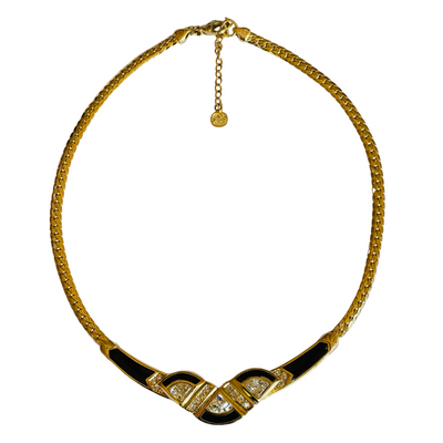 Gold necklace with black accents and gemstones on a white background