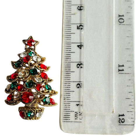 Butler & Wilson Christmas tree brooch with red, green, and clear gemstones on a white background shown next to ruler for scale 4.5 cm high approx.