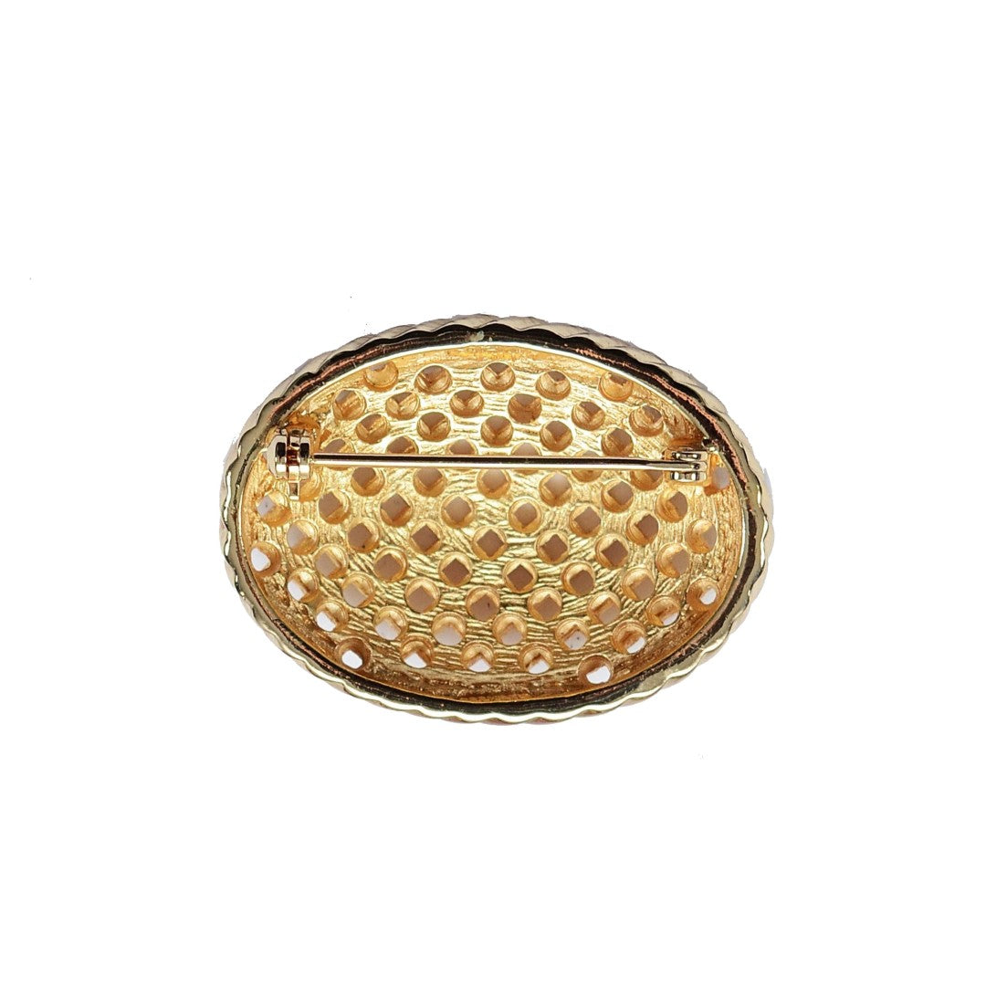 reverse side of Dior gold plated basket weave brooch on white background