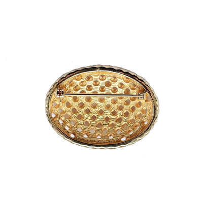 reverse side of Dior gold plated basket weave brooch on white background