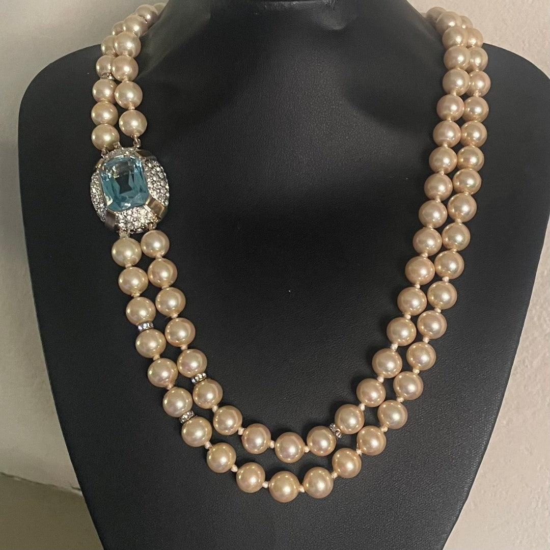 Vintage Vogue Bijoux double-strand faux pearl necklace with 10mm cream pearls, crystal rondelle spacers and an aquamarine crystal pavé-set clasp, 1980s.