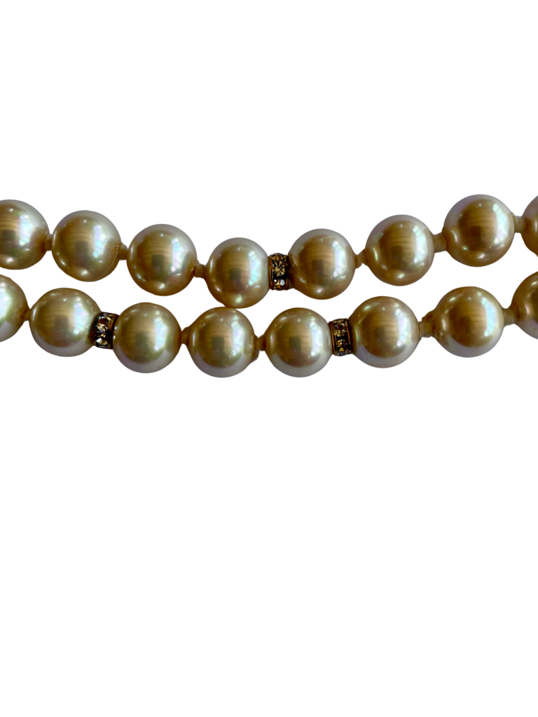 Vintage Vogue Bijoux double-strand faux pearl necklace with 10mm cream pearls, crystal rondelle spacers and an aquamarine crystal pavé-set clasp, 1980s.