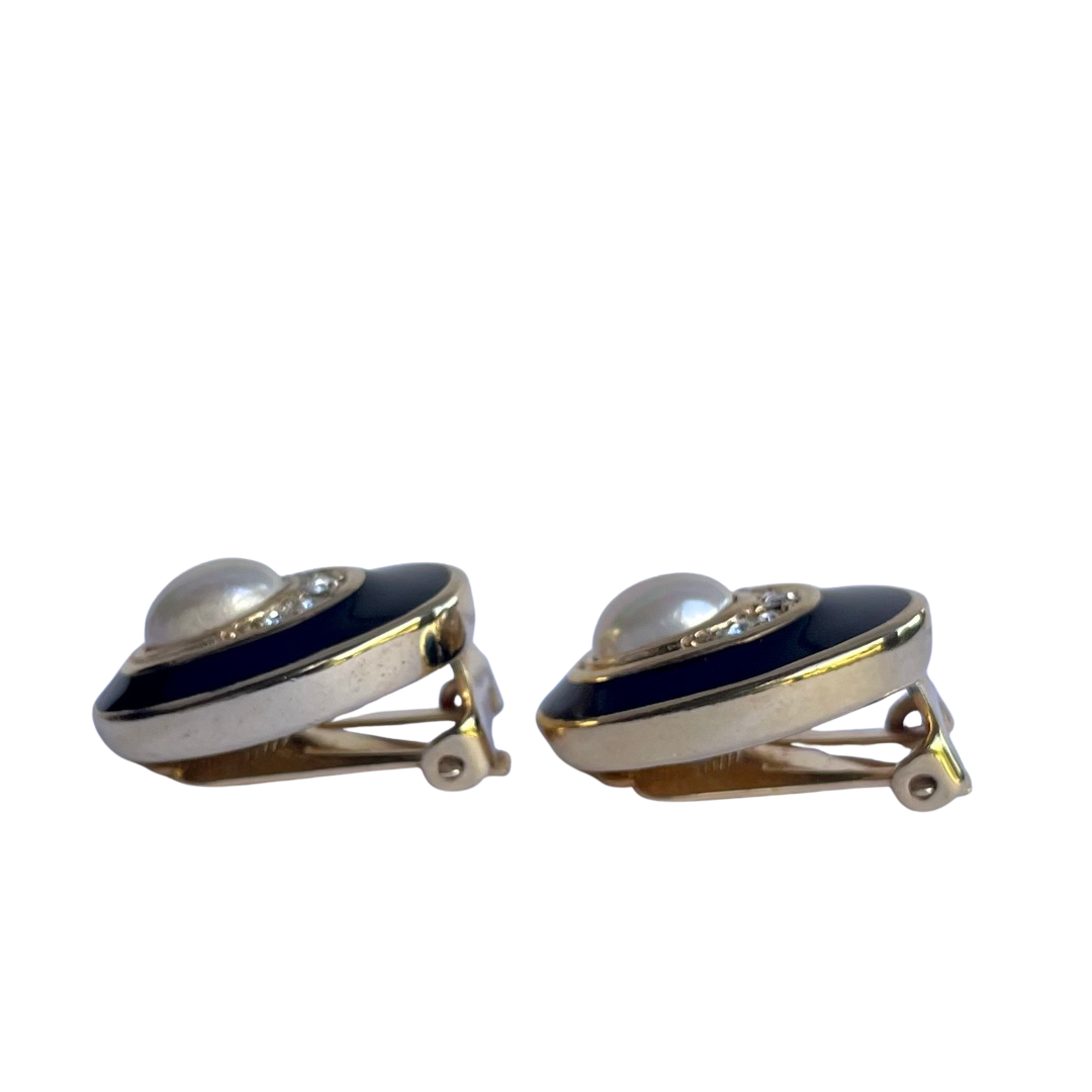 side view of Vintage Christian Dior gold plated oval clip earrings with faux mabé pearl, crystals and black enamel detailing