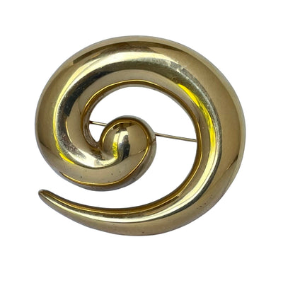 Monet gold plated spiral brooch on a white background