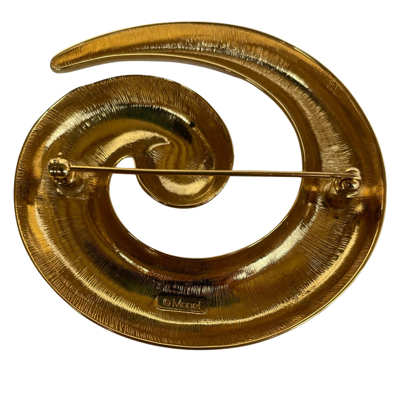 Monet gold plated spiral brooch on a white background showing Monet backstamp