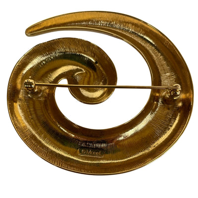 Monet gold plated spiral brooch on a white background showing Monet backstamp