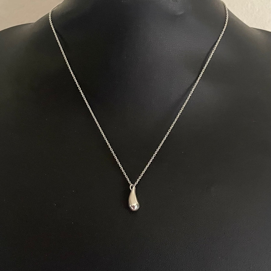 Tiffany and Co. Elsa Peretti sterling silver teardrop pendant necklace shown on a black bust