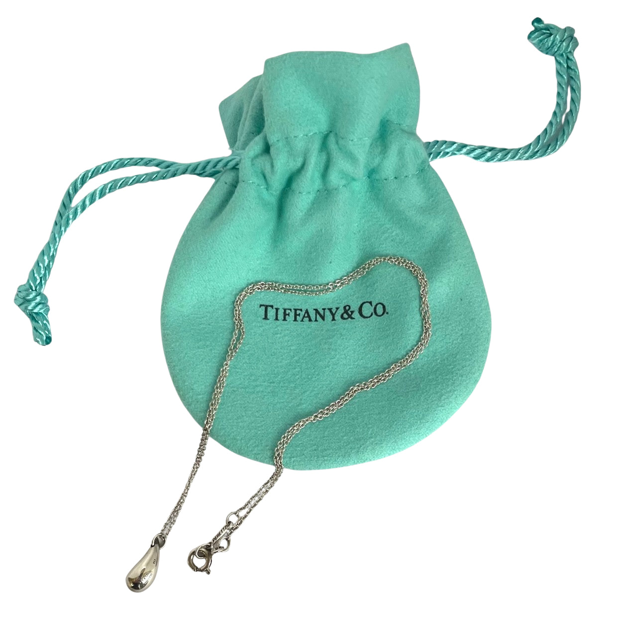 Tiffany and Co. Elsa Peretti sterling silver teardrop pendant necklace shown with blue drawstring pouch on a white background