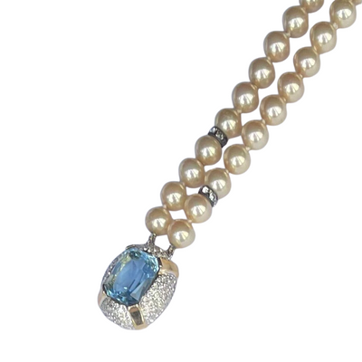 detail view of a 1980s Vogue Bijoux double-strand pearl bracelet. Displays 10mm cream pearls with crystal rondelles and a large aquamarine clasp.