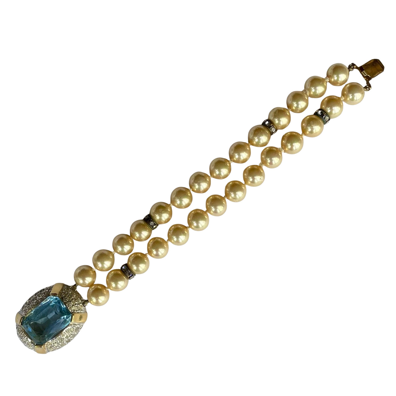 Full-length view of a 1980s Vogue Bijoux double-strand pearl bracelet. Displays 10mm cream pearls with crystal rondelles and a large aquamarine clasp.