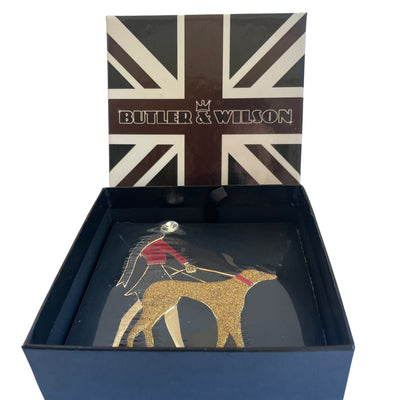 Butler and Wilson Art Deco brooch of a flapper lady in red enamel walking a gold glitter hound dog in a Union Jack box.