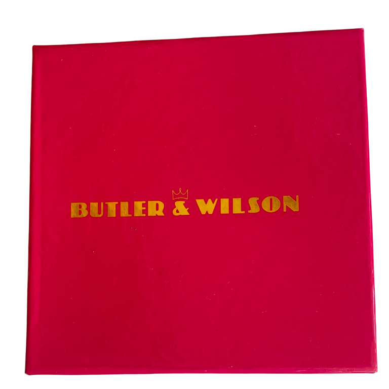 Butler & Wilson pink box containing Gold-tone Butler & Wilson suitcase keyring encrusted with red crystals, featuring "Paris," "New York," and "LA" stamps