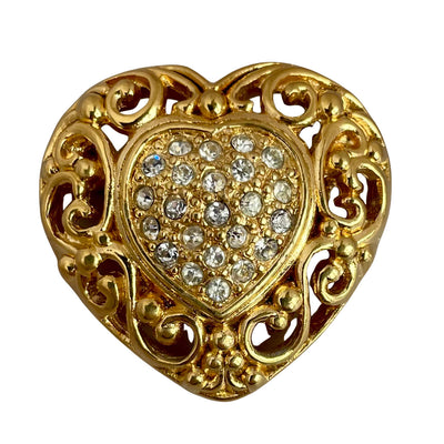 1980s Christian Dior gold-plated filigree heart brooch with a crystal-encrusted pavé centre heart, showing intricate baroque style scrollwork. set against a plain white background.
