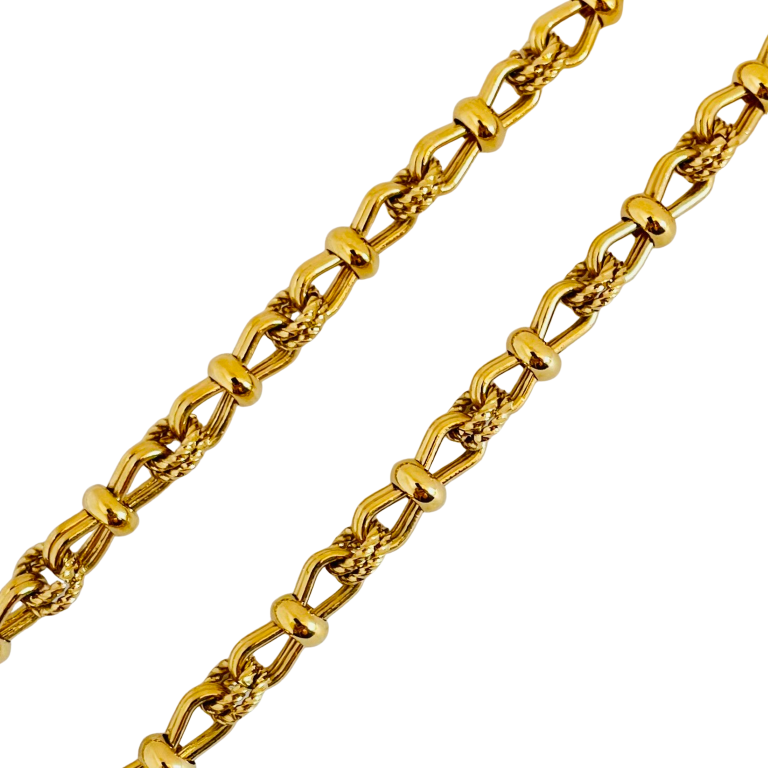 close up of Vintage 1980s Christian Dior matinee length chain necklace in 18ct yellow gold plating, featuring an alternating pattern of stylized figure-of-eight links and textured rope-twist segments, displayed on white background