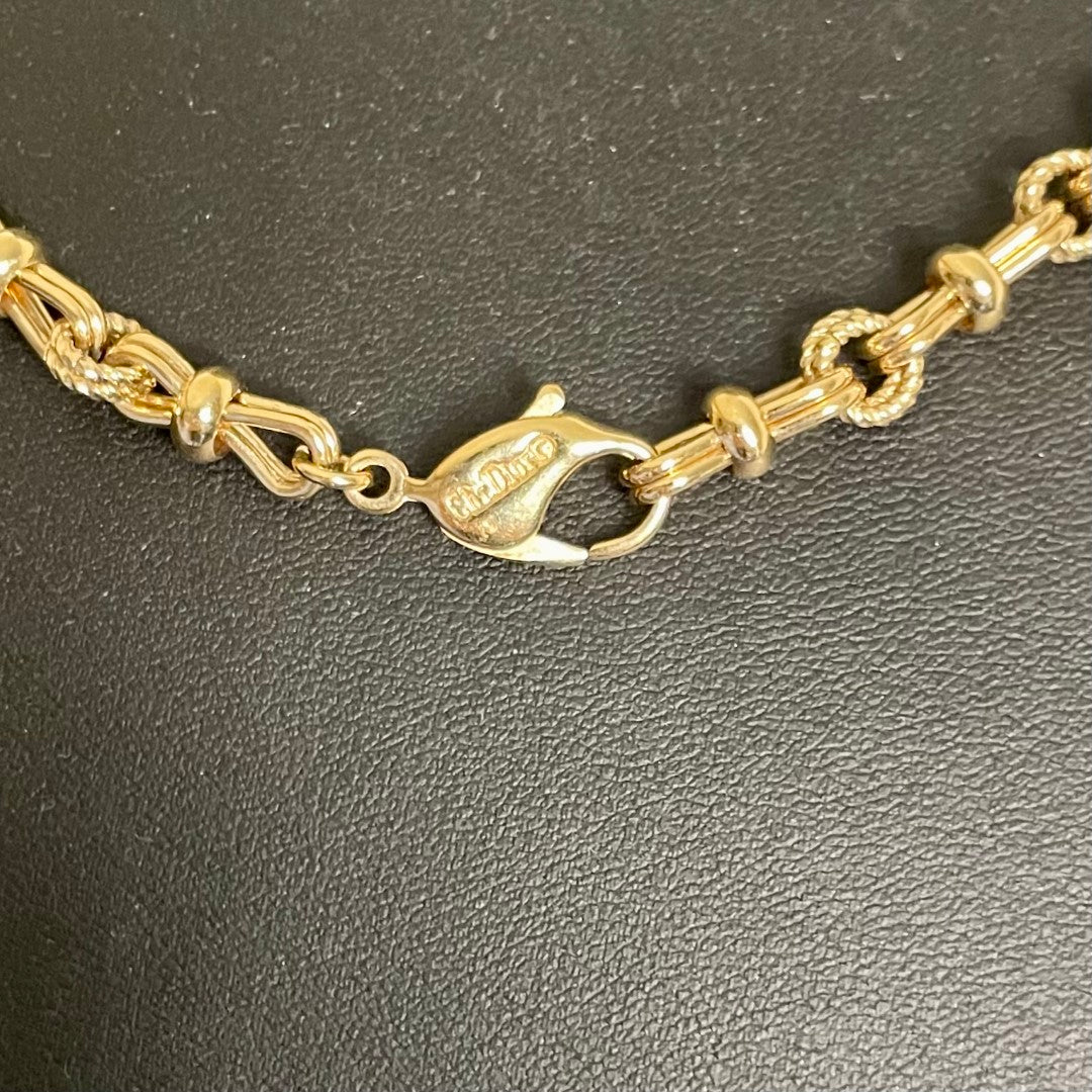 Close up of Chr. Dior logo  Vintage 1980s Christian Dior matinee length chain necklace in 18ct yellow gold plating, featuring an alternating pattern of stylized figure-of-eight links and textured rope-twist segments, displayed on white background