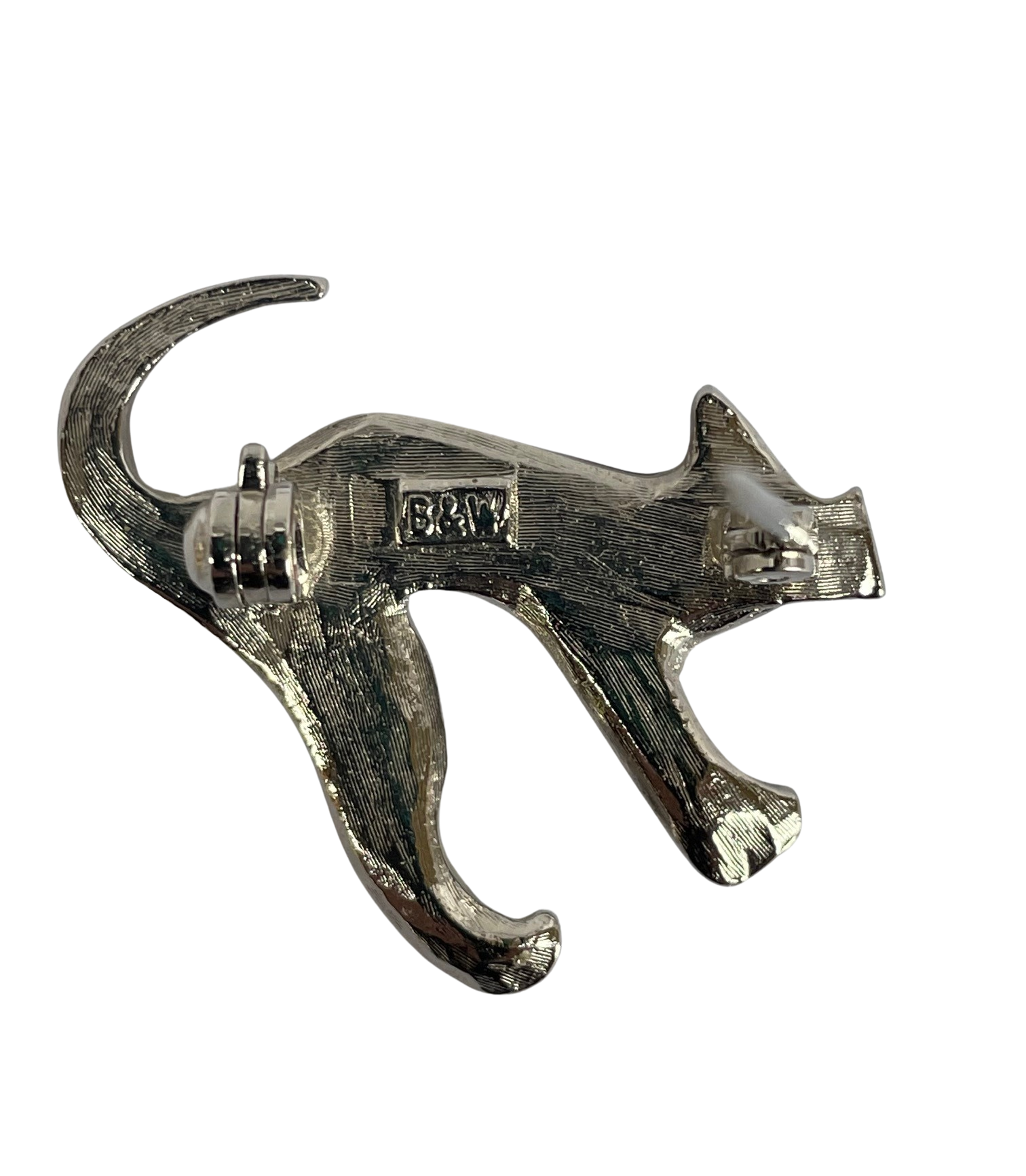 The textured silver-tone reverse side of the Butler & Wilson cat brooch, displaying the authentic stamped "B&W" makers mark inside a rectangular cartouche and a functional revolver safety clasp.
