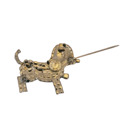 reverse of vintage Butler & Wilson silver-tone crystal puppy dog brooch with black eye patch, ruby-red crystal collar and amber crystal charm, showing open pin and Butler & Wilson signature in circular cartouche.