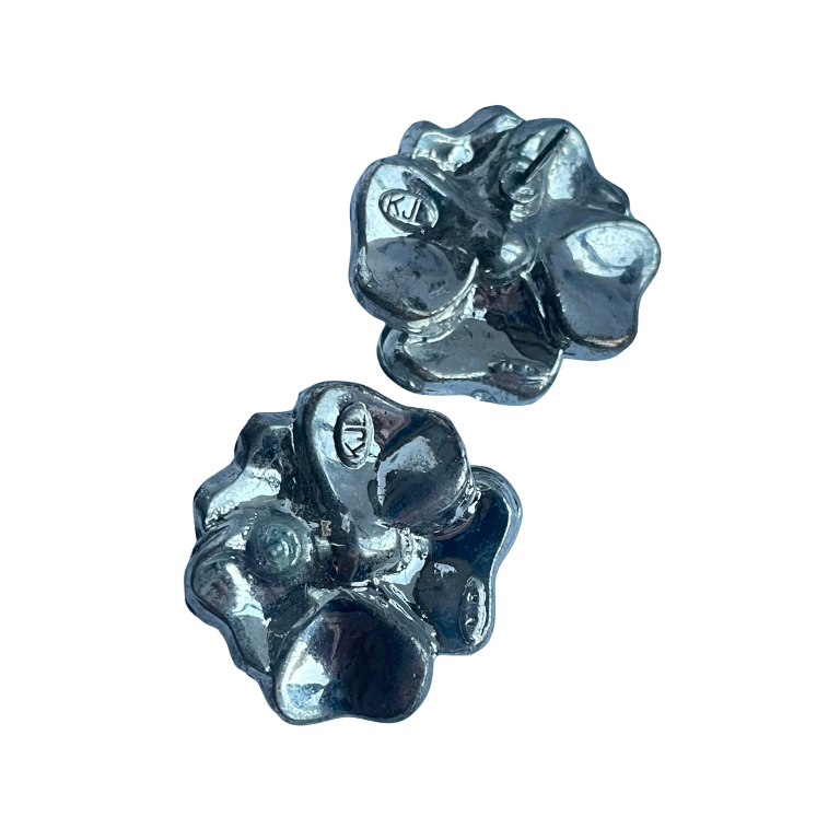 Reverse side of vintage Kenneth Jay Lane camellia earrings showing pierced post fastenings with  the stamped KJL logo.