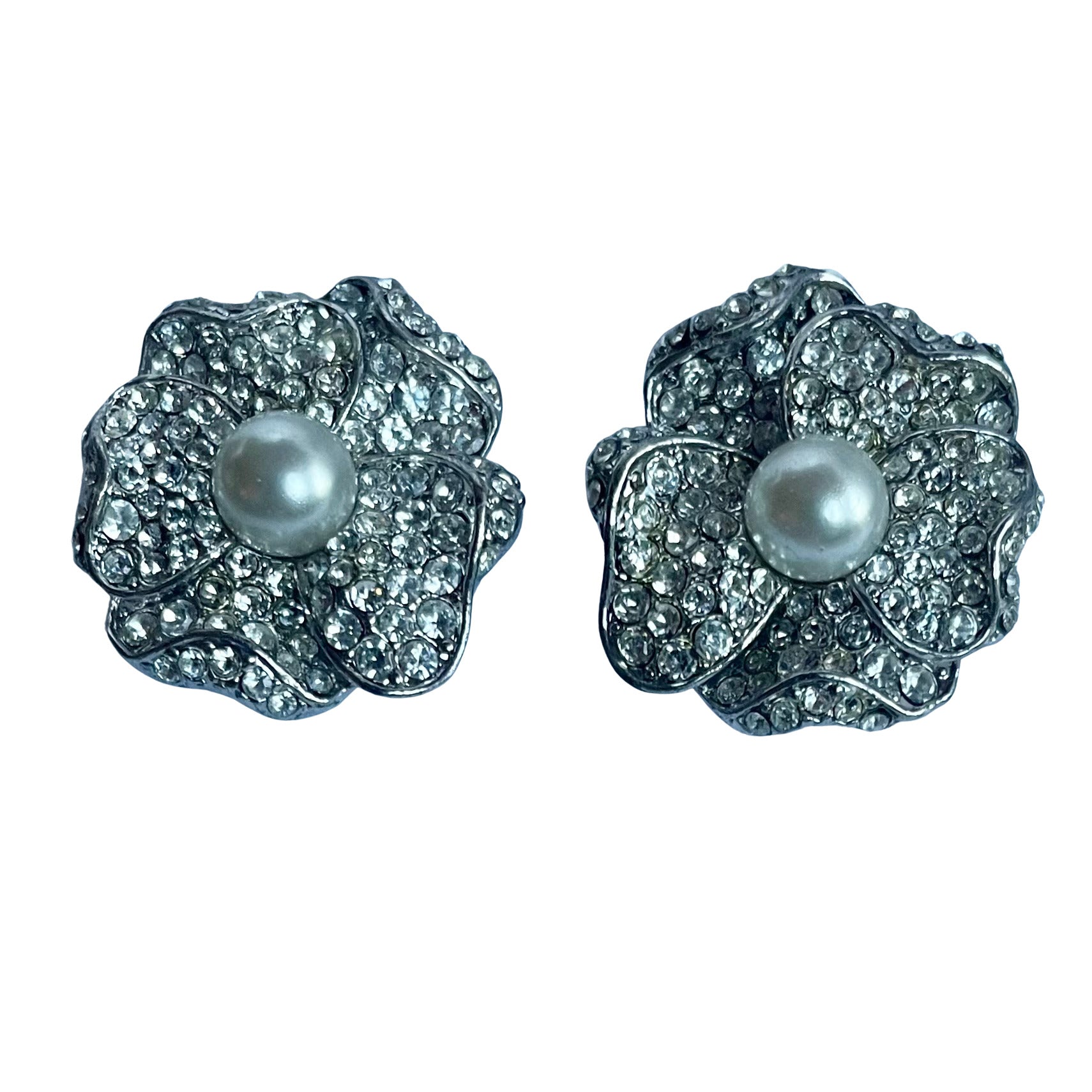 Mid-1990s vintage Kenneth Jay Lane camellia clip earrings featuring layered petals set with brilliant pavé crystals and anchored by a central faux pearl.