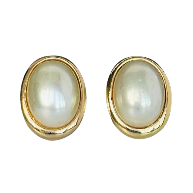 signed Christian Dior Germany vintage costume jewellery, gold plated oval pearl earrings on a plain white backdrop.