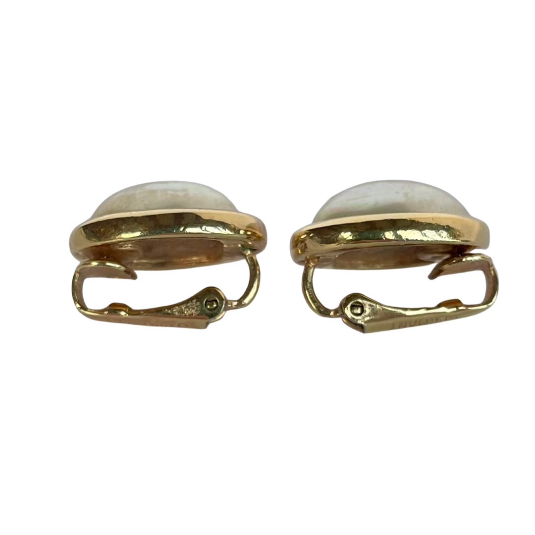 side view of signed Christian Dior Germany vintage costume jewellery, gold plated oval pearl earrings on a plain white backdrop.