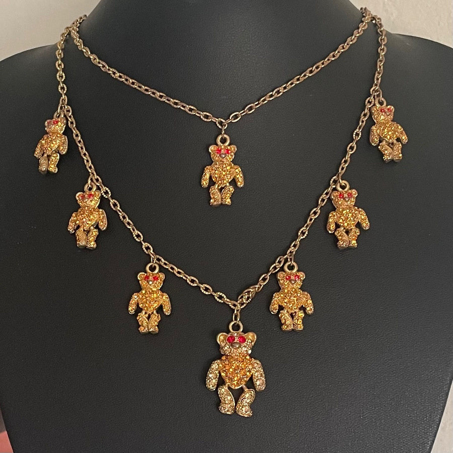 Gold necklace with teddy bear pendants on a black mannequin