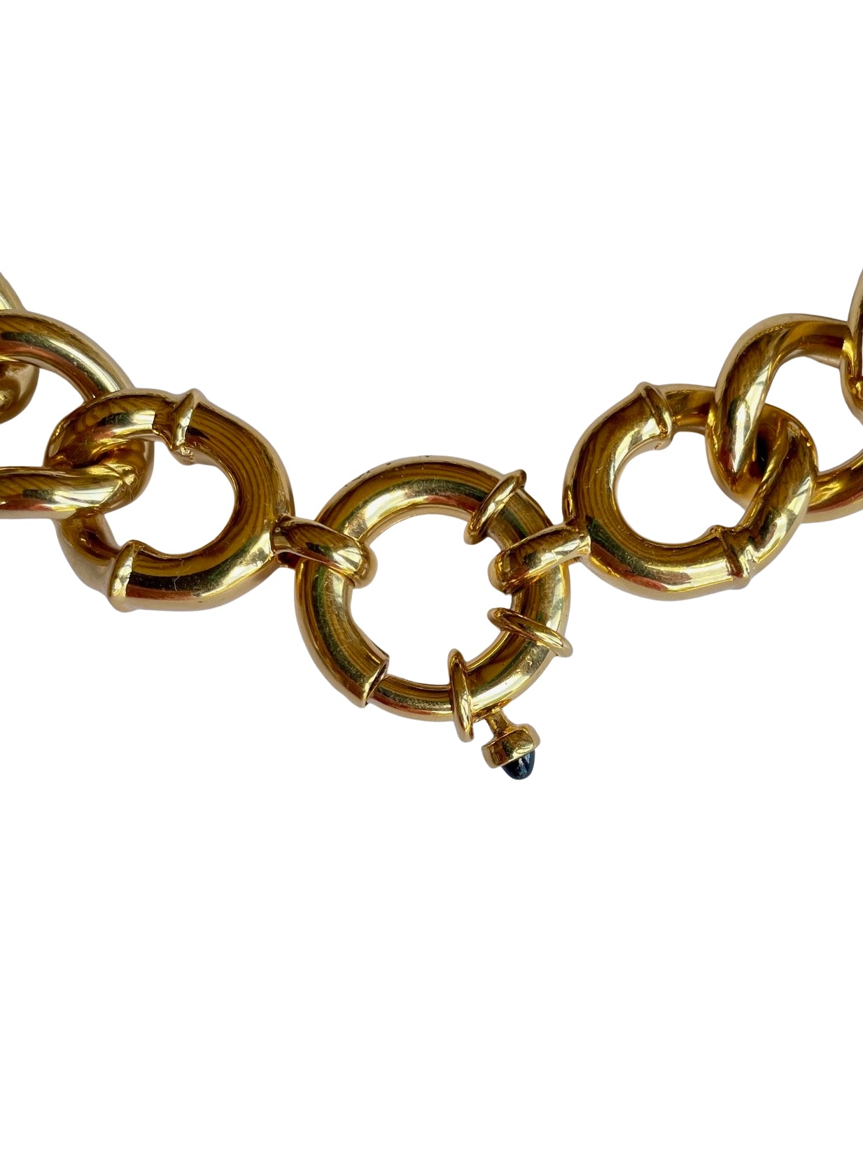 Close-up of a heavy 1990s gold-plated spring bolt ring sailor clasp with dome-cut black cabochon crystal trigger lever.