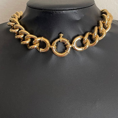 The reverse side of a 90s vintage Alpha Jewels gold collar necklace showcasing the decorative fluted bolt ring clasp and  transition loops which can also be worn facing forward