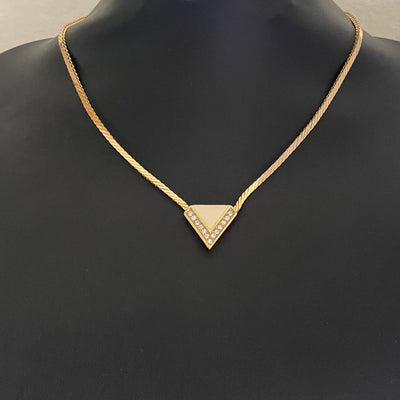 Gold-plated Art Deco style Christian Dior geometric triangle necklace with cream enamel and clear crystal accents displayed on black bust.